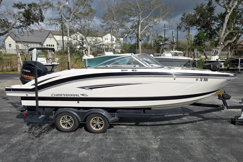 Slide: The Image of 2019 Chaparral 230 Suncoast boat on trailer, parked outdoors. - 2