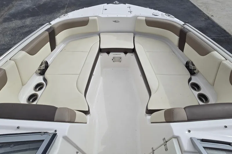 Slide: The Image of 2019 Chaparral 230 Suncoast boat interior with beige seating and cup holders. - 21