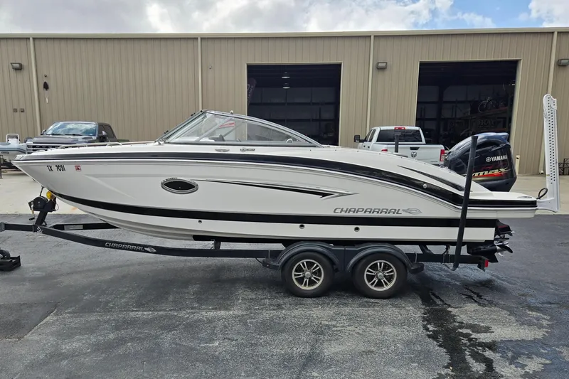 Slide: The Image of 2019 Chaparral 230 Suncoast boat on trailer, parked outside a warehouse. - 6