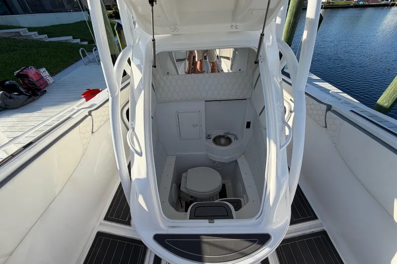 Slide: The Image of 2022 Glasstream 328 Pro-XS boat interior with open hatch and marine toilet. - 29