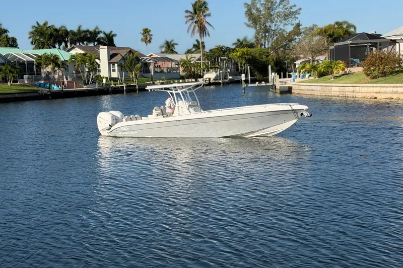 Slide: The Image of 2022 Glasstream 328 Pro-XS boat on a calm waterway, surrounded by lush greenery. - 3