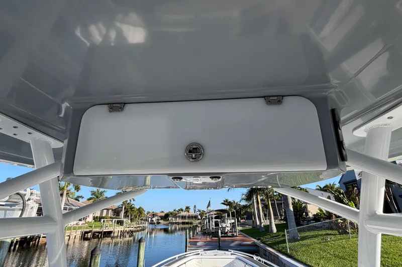 Slide: The Image of 2022 Glasstream 328 Pro-XS boat interior with storage compartment, docked near waterfront homes. - 37