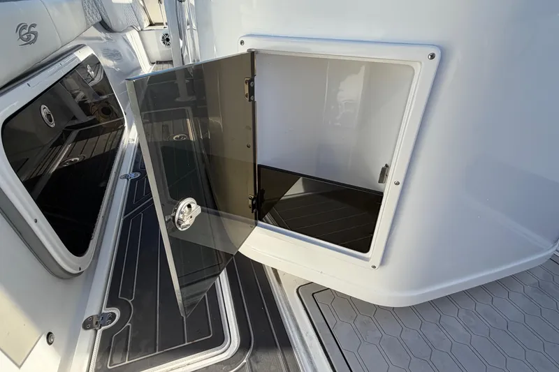 Slide: The Image of 2022 Glasstream 328 Pro-XS boat storage compartment with open door, showcasing sleek interior design. - 44