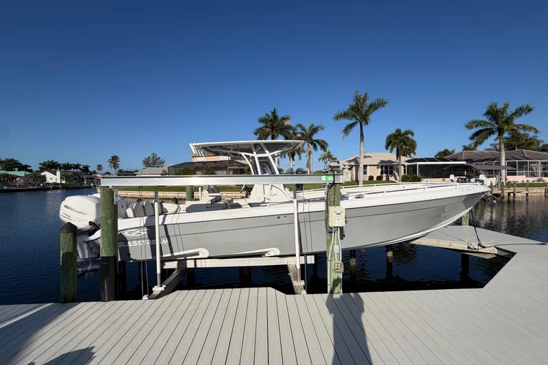 Slide: The Image of 2022 Glasstream 328 Pro-XS boat docked by waterfront homes and palm trees. - 54