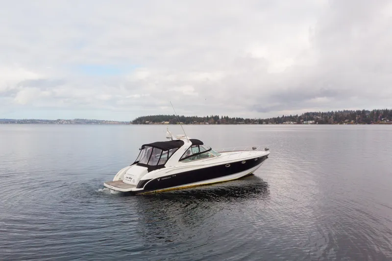 Slide: The Image of 2005 Formula 400 Super Sport boat cruising on a calm lake under cloudy skies. - 1