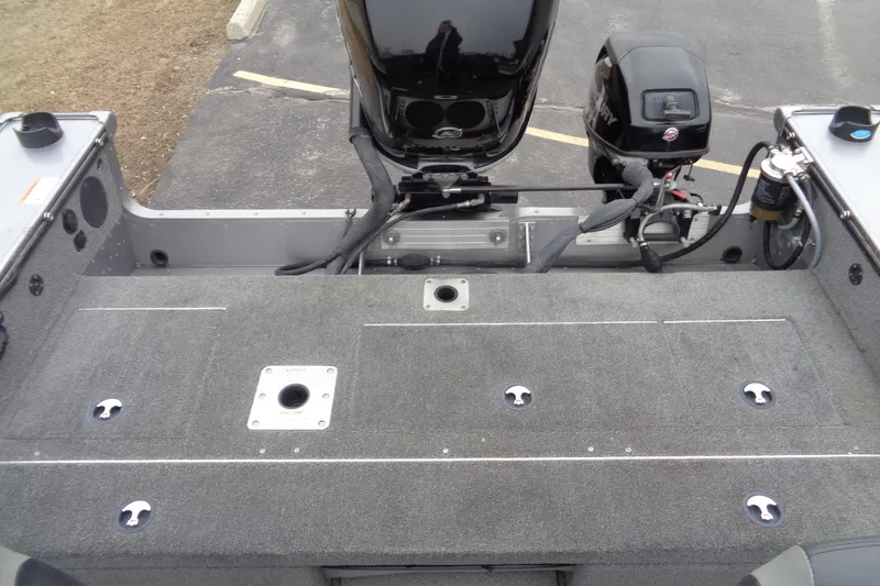 Slide: The Image of 2016 Lund 2175 Pro-V boat interior with motor and carpeted deck. - 21