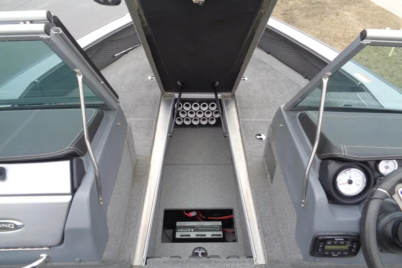 Slide: The Image of 2016 Lund 2175 Pro-V boat interior with open storage compartment and dashboard view. - 22