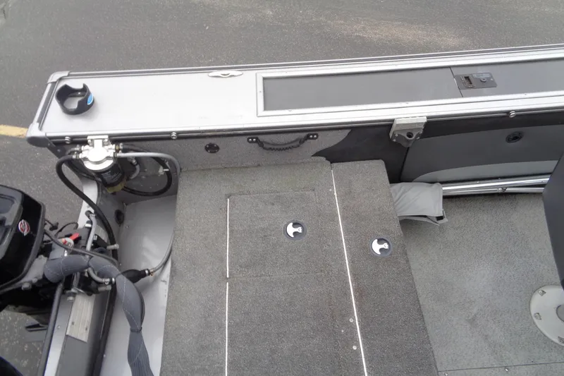 Slide: The Image of 2016 Lund 2175 Pro-V boat interior with carpeted deck and motor components. - 24