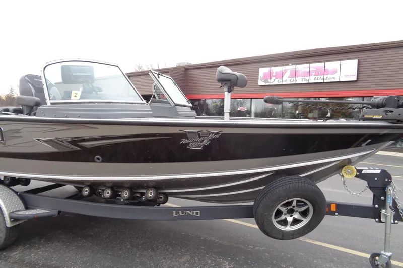Slide: The Image of 2016 Lund 2175 Pro-V boat on trailer, parked outside a store. - 6