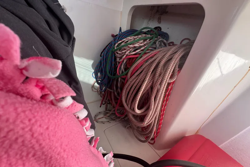 Slide: The Image of Coiled ropes in a Flying Tiger 10M sailboat, 2007 model, with pink fabric nearby. - 23