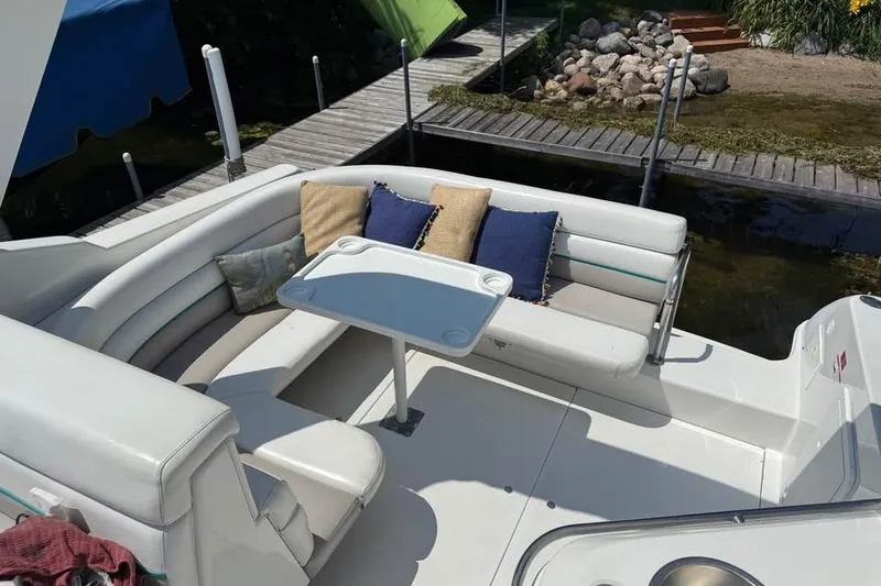 Slide: The Image of 1995 Chris Craft 34 Crowne boat interior with seating and table by a dock. - 5