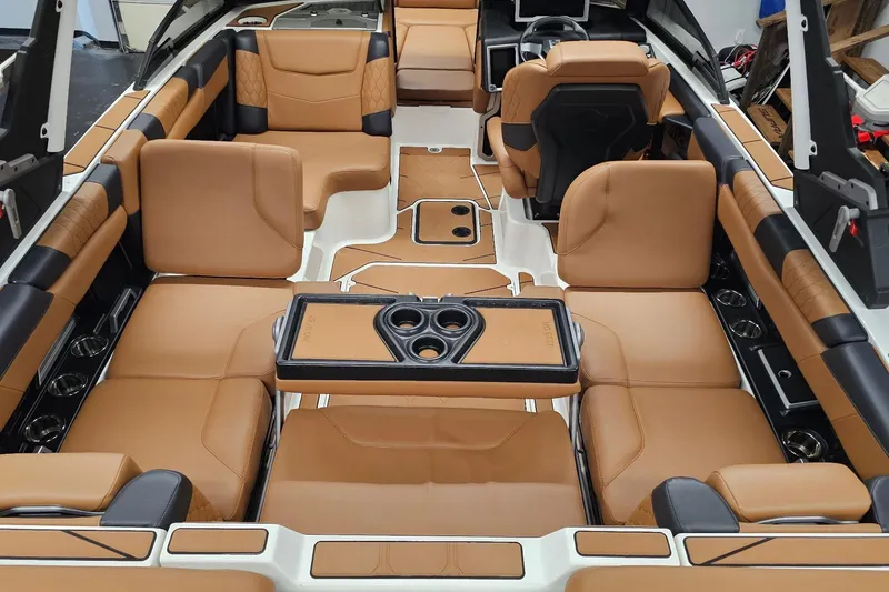 Slide: The Image of Luxurious interior of 2023 Malibu M220 boat with tan leather seating and cup holders. - 12