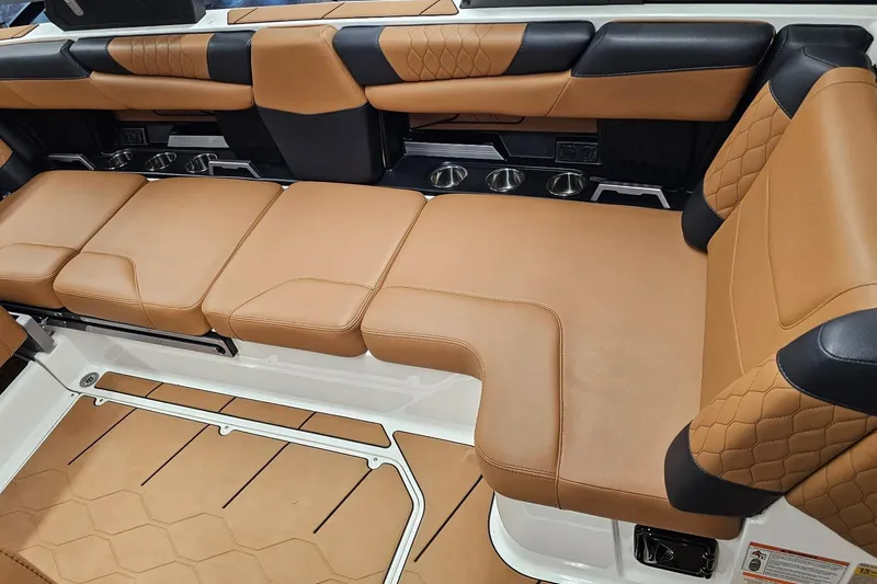 Slide: The Image of 2023 Malibu M220 boat interior with luxurious tan and black seating. - 13