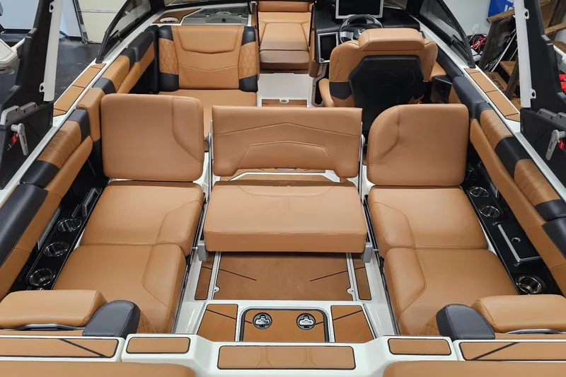 Slide: The Image of 2023 Malibu M220 boat interior with luxurious tan leather seating and modern design. - 14