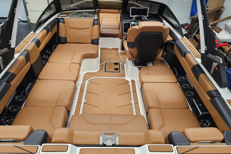 Slide: The Image of 2023 Malibu M220 boat interior with luxurious tan and black seating, modern design. - 15