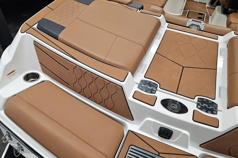 Slide: The Image of 2023 Malibu M220 boat interior with tan and black upholstery, featuring modern design elements. - 16