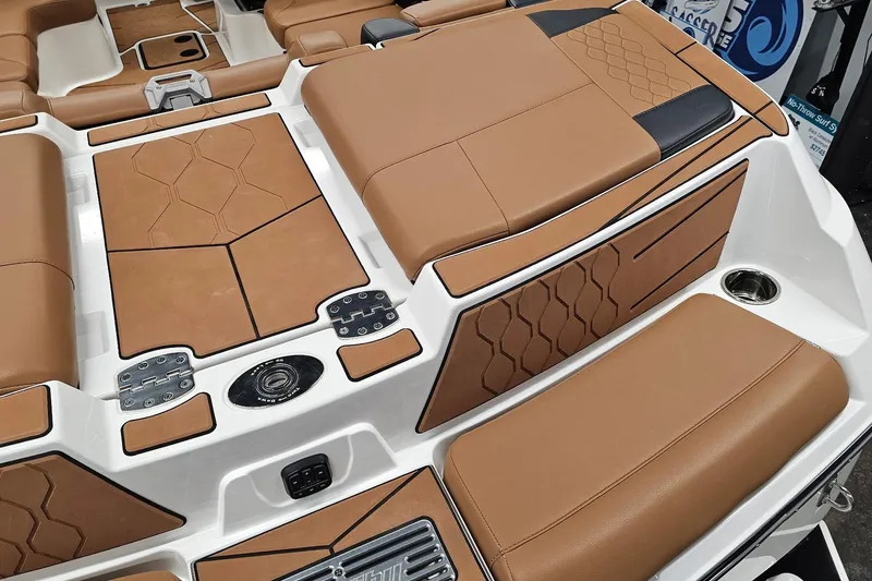Slide: The Image of 2023 Malibu M220 boat interior with tan upholstery and geometric design accents. - 17