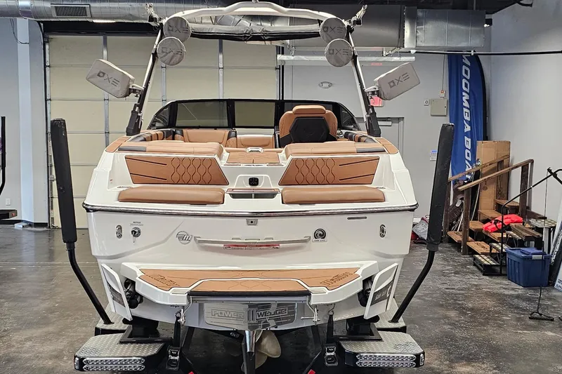 Slide: The Image of 2023 Malibu M220 boat in showroom, featuring luxurious tan seating and advanced sound system. - 19