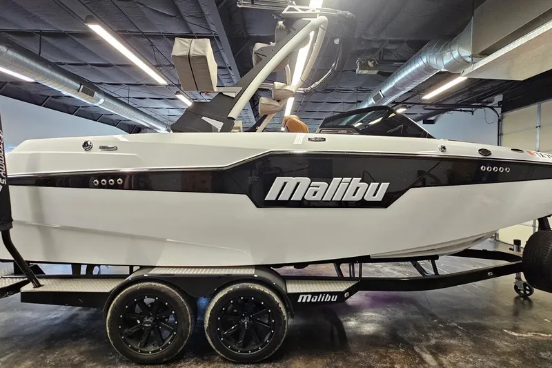 Slide: The Image of 2023 Malibu M220 boat on trailer in showroom, side view. - 21