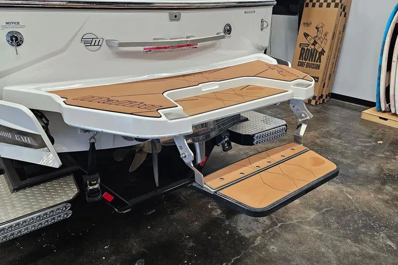 Slide: The Image of 2023 Malibu M220 boat swim platform with tan padding and foldable step. - 23