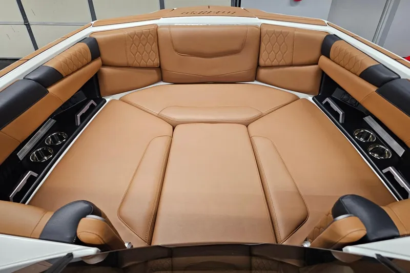 Slide: The Image of 2023 Malibu M220 boat interior with luxurious tan leather seating and cup holders. - 6