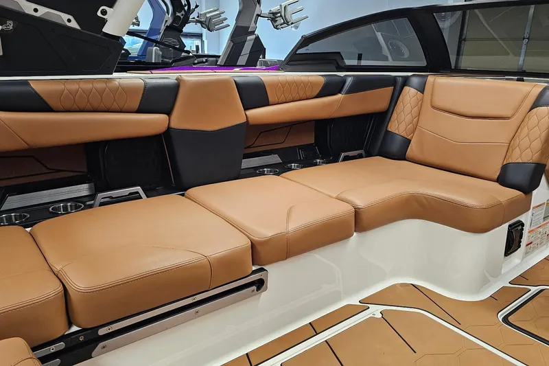 Slide: The Image of 2023 Malibu M220 boat interior with luxurious tan and black seating. - 9