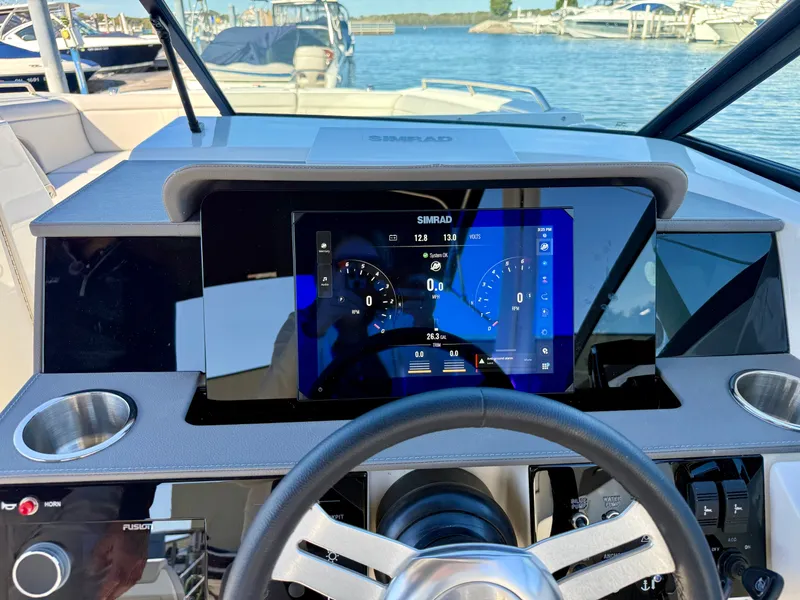 Slide: The Image of The image shows the helm of a Sea Ray SDX 290 Outboard with a modern Simrad display. - 13