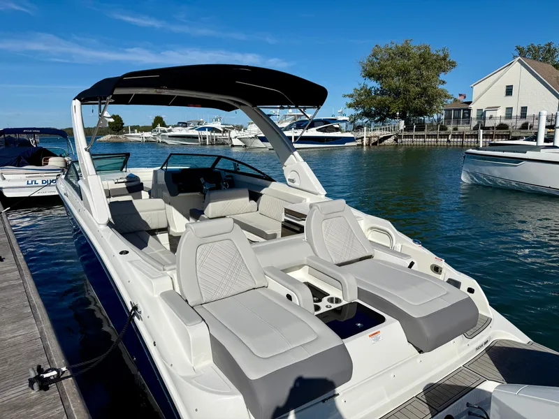 Slide: The Image of The image shows a 2026 Sea Ray SDX 290 Outboard boat docked at a pier. - 2