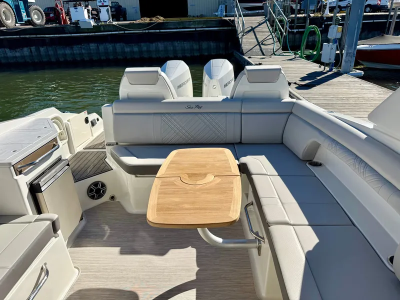 Slide: The Image of The image shows the cockpit of a Sea Ray SDX 290 Outboard with beige seating and a wooden table. - 16