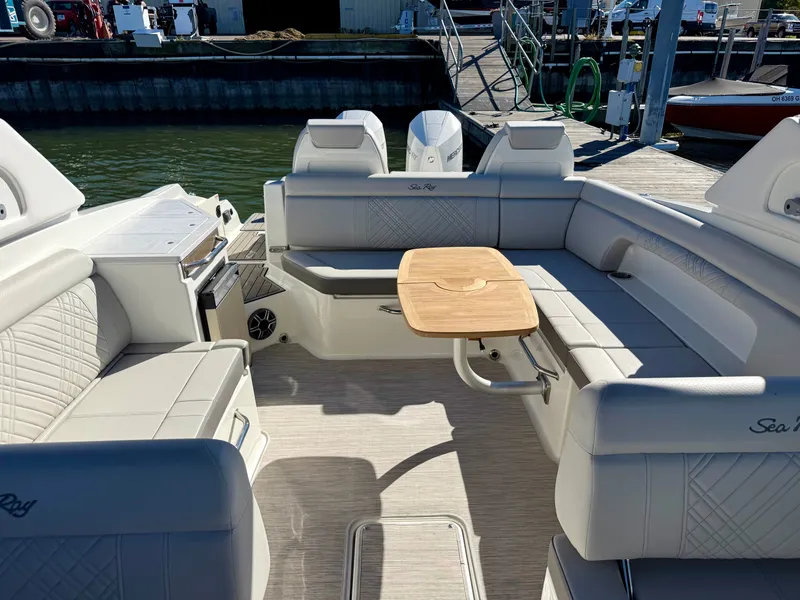 Slide: The Image of Interior of a Sea Ray SDX 290 Outboard with sleek seating and a wooden table. - 8