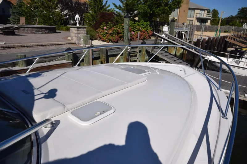 Slide: The Image of 2009 Jupiter 39 Express boat docked, featuring sleek white deck and stainless steel railings. - 20