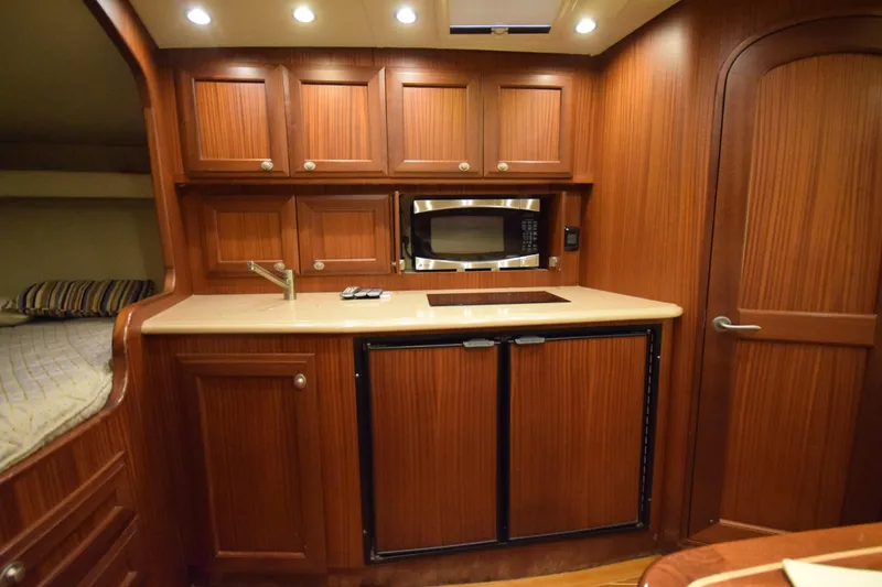 Slide: The Image of Luxurious 2009 Jupiter 39 Express yacht interior with wood cabinetry and modern kitchen amenities. - 25