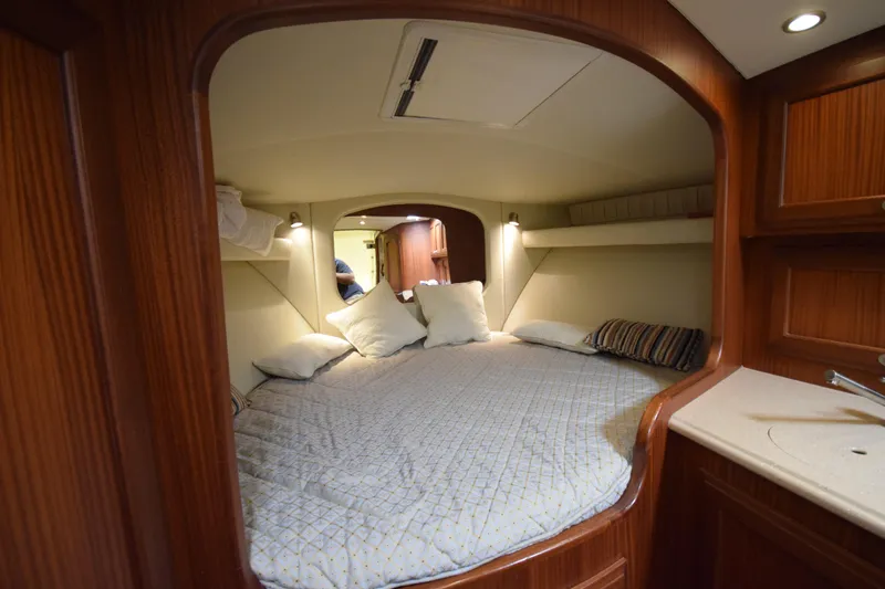Slide: The Image of Cozy cabin interior of 2009 Jupiter 39 Express boat with comfortable bedding and wooden finish. - 26