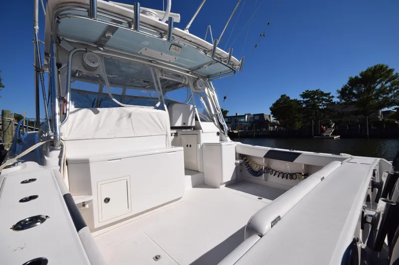 Slide: The Image of 2009 Jupiter 39 Express boat with spacious deck and seating, docked by the water. - 3