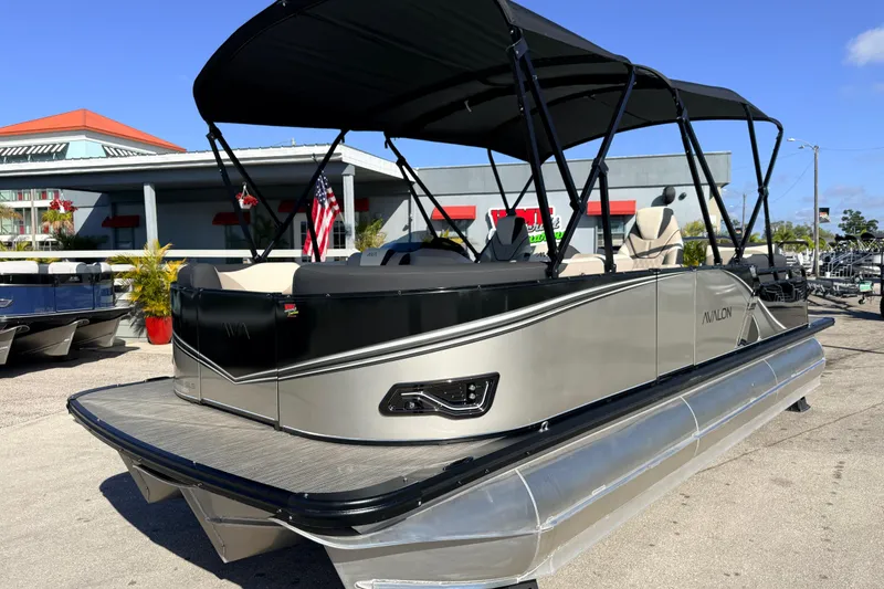 The Image of 2026 Avalon 2585 LSZ Quad Lounger Tri Toon boat with canopy, parked outdoors. - 1
