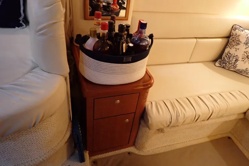 Slide: The Image of Interior of 2002 Sea Ray 340 Sundancer with a cozy seating area and a liquor basket. - 105