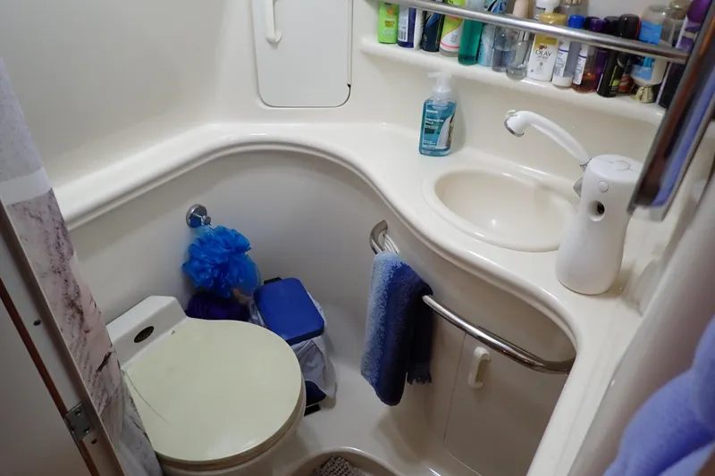 Slide: The Image of Compact bathroom in 2002 Sea Ray 340 Sundancer yacht with sink, toilet, and toiletries. - 11