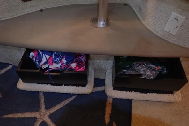 Slide: The Image of Storage area with boxes under a table on a 2002 Sea Ray 340 Sundancer boat. - 116