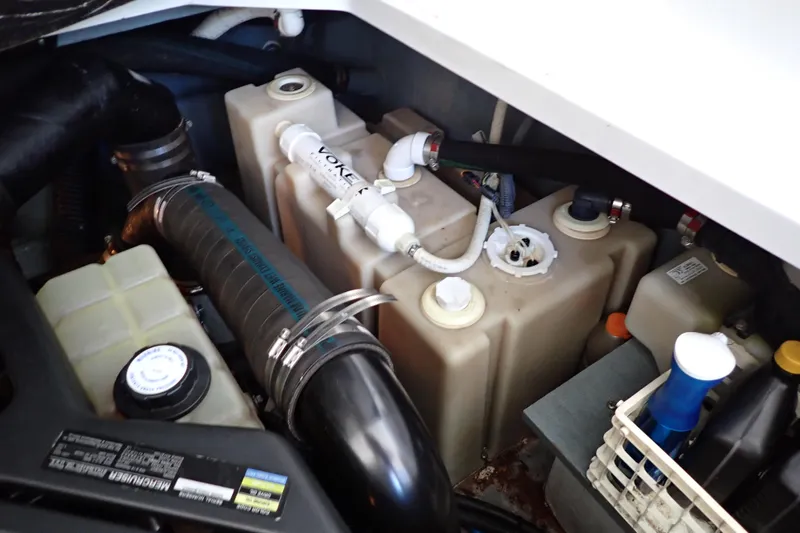 Slide: The Image of Engine compartment of a 2002 Sea Ray 340 Sundancer boat, showing various components and hoses. - 145
