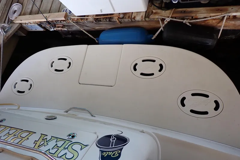 Slide: The Image of 2002 Sea Ray 340 Sundancer swim platform with storage hatches, docked in a marina. - 23