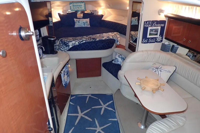 Slide: The Image of 2002 Sea Ray 340 Sundancer cabin interior with cozy seating, bed, and nautical decor. - 25