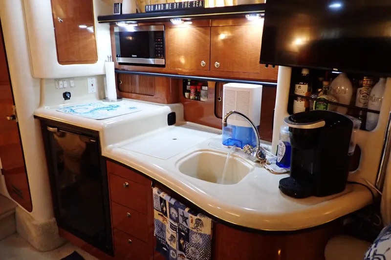 Slide: The Image of 2002 Sea Ray 340 Sundancer kitchen with sink, microwave, and coffee maker. - 32