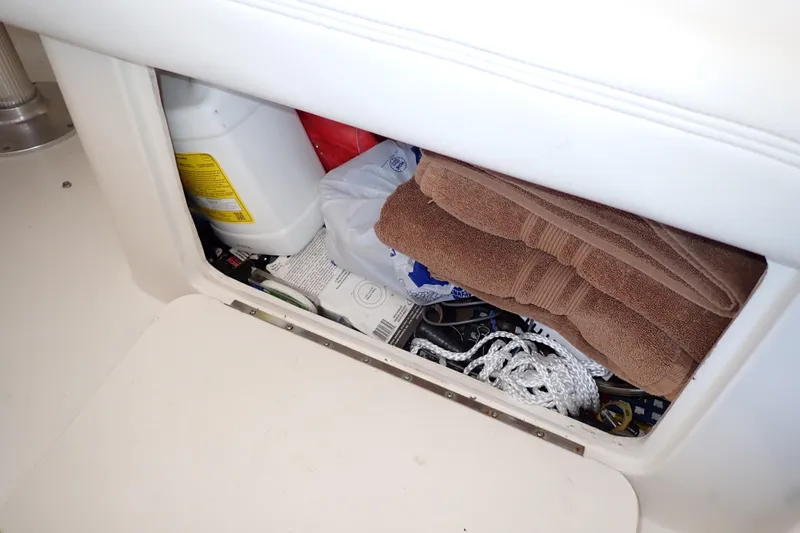 Slide: The Image of Storage compartment on a 2002 Sea Ray 340 Sundancer with towels and boating supplies. - 63