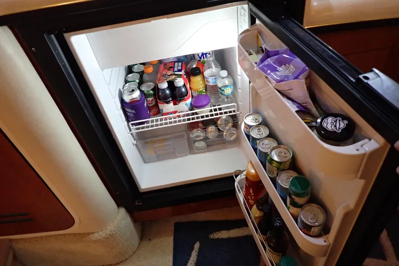 Slide: The Image of Mini fridge stocked with drinks and snacks inside a 2002 Sea Ray 340 Sundancer boat. - 74