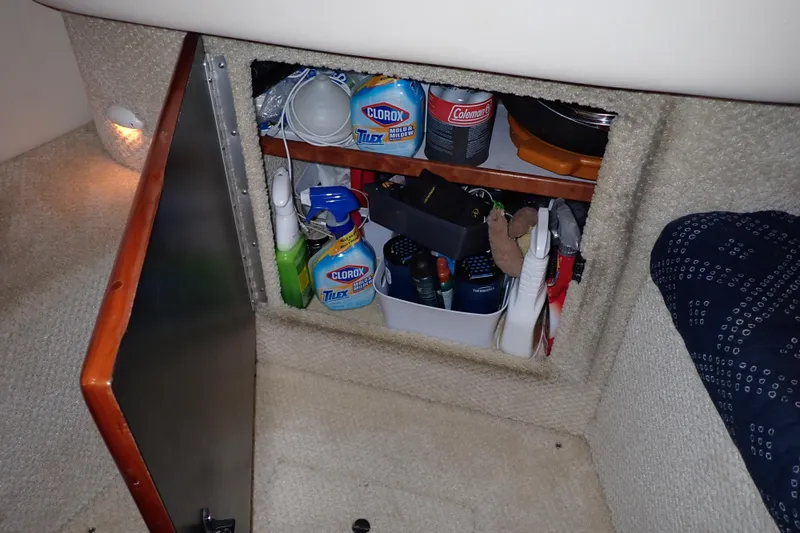 Slide: The Image of Storage compartment on a 2002 Sea Ray 340 Sundancer with cleaning supplies and tools. - 82