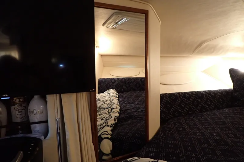 Slide: The Image of Interior cabin of 2002 Sea Ray 340 Sundancer with cozy bedding and TV. - 89