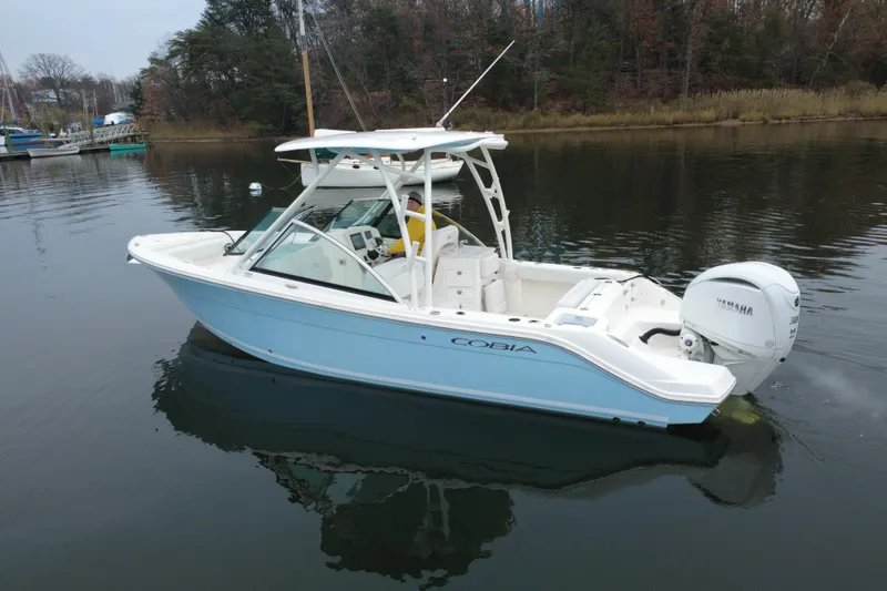 The Image of 2024 Cobia 240 Dual Console boat on calm water, featuring Yamaha outboard engine. - 0