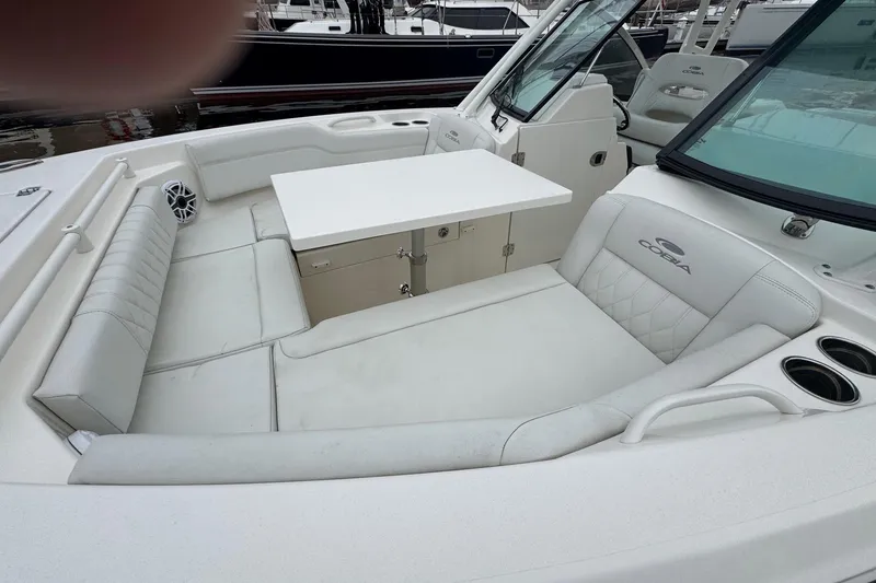 Slide: The Image of 2024 Cobia 240 Dual Console boat interior with seating and table setup. - 18
