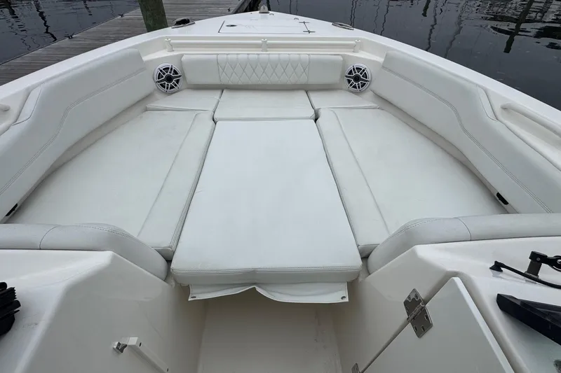 Slide: The Image of 2024 Cobia 240 Dual Console boat interior with white cushioned seating and speakers. - 19