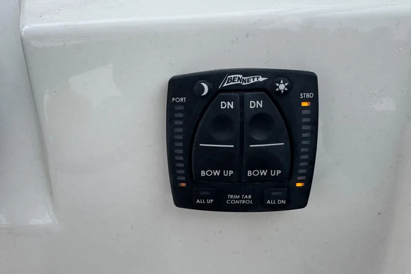 Slide: The Image of Bennett trim tab control on 2024 Cobia 240 Dual Console boat dashboard. - 25